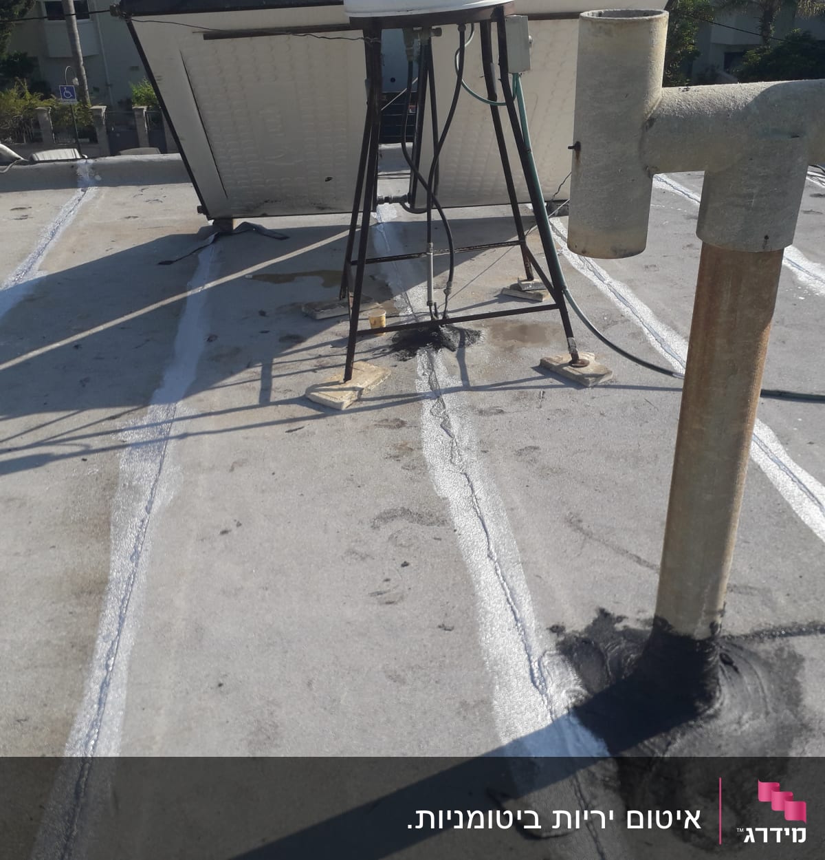 איטום גג עם חומר שחור סביב צינור
